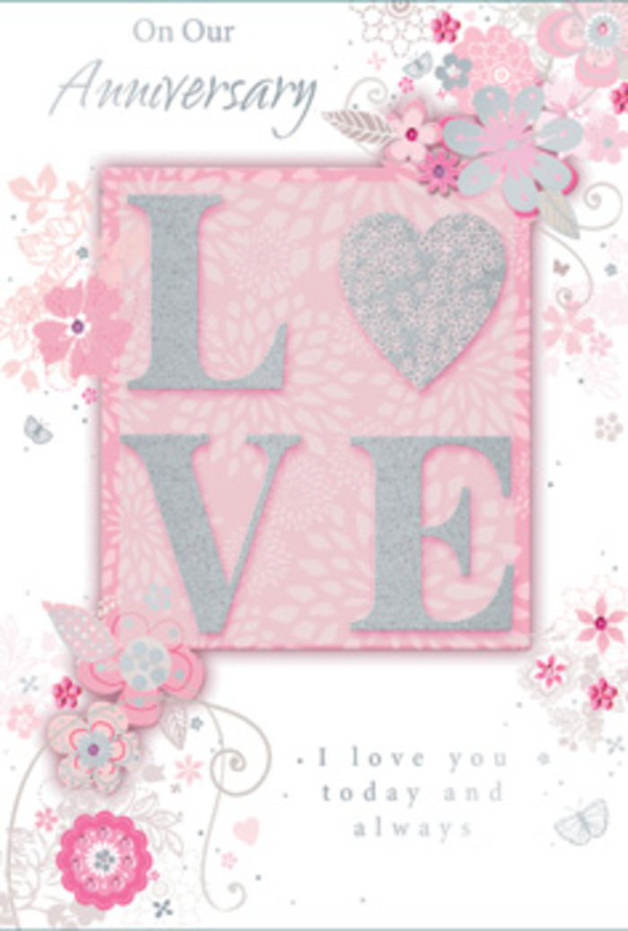 This photograph features an anniversary card whose design evokes the feeling of stepping into a sunlit room high above Aldgate, where life slows for a moment to honour everyday love. The central motif is the word LOVE, set in refined lettering and finished with frosted glitter that appears slightly raised, as though inviting you to trace its contours with your fingertips. The shimmer is gentle and diffused, more like soft morning light reflecting on calm water than bright sparkle. Around this central word, wispy, hand-drawn flowers and delicate sprays frame the design, drifting along the top, sides, and bottom edges. Their colours are understated yet harmonious: blush pinks, muted lilacs, creamy ivory, and soft grey-silver. Each bloom is stylised, with elongated petals and slender stems that curve gracefully, recalling both fine stationery and the flowing lines of a well-designed bouquet from Aldgate Flowers. Interwoven with the blossoms are filigree flourishes - loops, curls, and dainty leaves - and, if you look closely, a scattering of almost-hidden butterflies that hover like a quiet flutter of excitement before an anniversary toast. The background blends soft pink panels with lighter, nearly white spaces that keep the card feeling bright and open, never heavy. Near the central motif, the message I love you today and always is printed in simple, elegant type, the words resting comfortably among the floral details rather than dominating them. The whole composition feels like a hand-tied bouquet in paper form, a tender mix of artistry and sentiment that might be chosen to accompany same-day anniversary flowers delivered across Aldgate's mix of historic lanes and modern apartments.