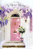 In this image, an Aldgate doorway has been turned into a small sanctuary, a softer moment within the city's busy grid of streets and offices. The front door is painted a delicate, rosy pink, its simple panels catching the ambient light in a way that makes the surface glow gently rather than shine. Around the door frame, wisteria cascades in loose, luxuriant falls, each arching stem heavy with tiny blossoms in shades of lavender, lilac, and muted mauve. The clusters drape like floral curtains, creating a natural archway that seems to lower the noise of the surrounding city and invite a slower breath. The wall around the door is whitewashed, lightly textured, reflecting light in soft patches, while a pale shutter reinforces the calm, pastel palette. Just at the threshold, centered on the step, stands a sturdy grey metal bucket, pressed into service as a charmingly informal vase. It is filled to overflowing with creamy white roses, their petals velvety and tightly layered, forming rounded blooms that press gently against one another. Between the roses, sprigs of soft green foliage peek out, adding a subtle, garden-like freshness to the compact urban space. A satin ribbon in a pale pink hue is tied neatly around the bucket, its bow resting gracefully against the metal, echoing the colour of the door and unifying the scene. The overall mood is one of hopeful transition and gentle celebration, as though a local florist has placed this arrangement to welcome someone moving into a new Aldgate apartment, offering them a daily reminder-each time they turn the key-that their home can be an oasis of calm, beauty, and quiet happiness.